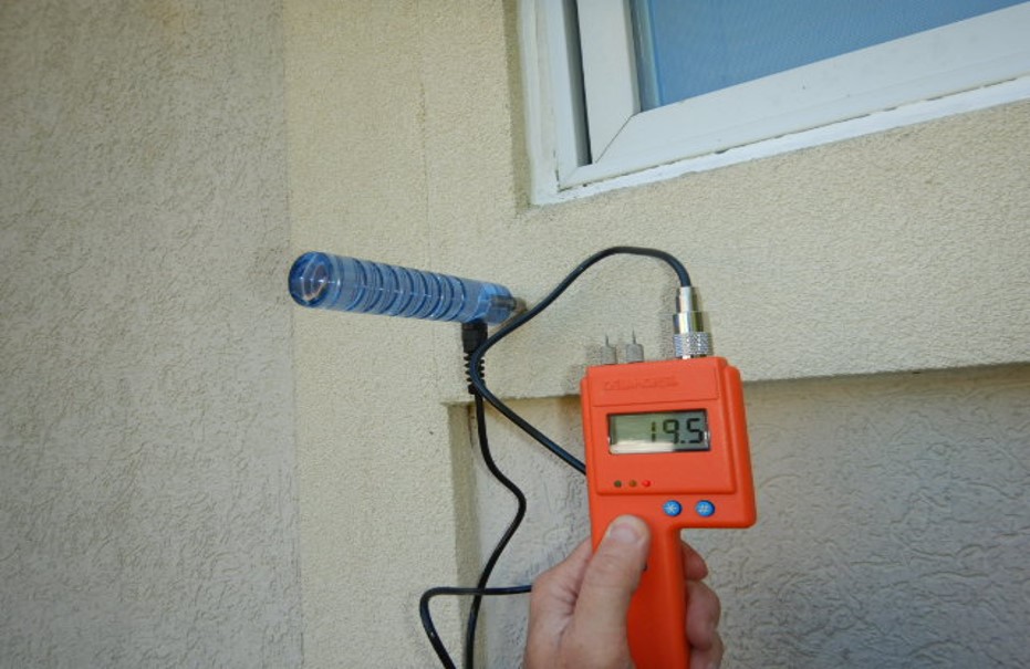 man holding an orange inspection device with a black wire